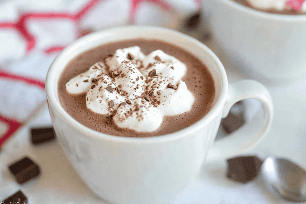 a cup of hot chocolate with whipped cream and chocolate chips